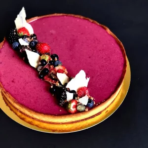 Große Beerentarte mit intensiver Beerenfüllung, knusprigem Tarteboden und frischen Beeren auf dunklem Hintergrund